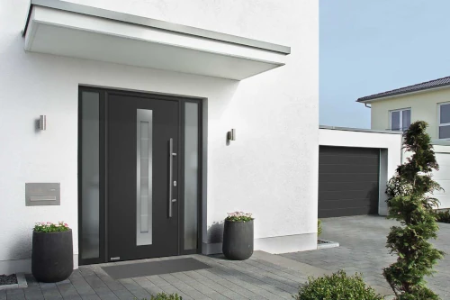 Moderne Haustür aus Aluminium mit Glas-Elementen an weißem Einfamilienhaus und Garage.